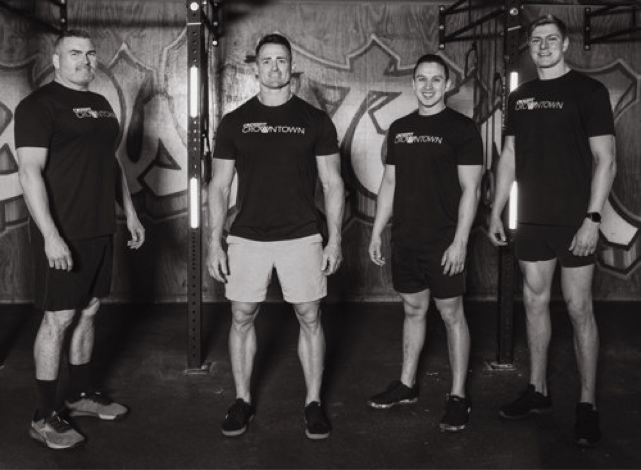 Four CrossFit CrownTown coaches in a black and white team portrait